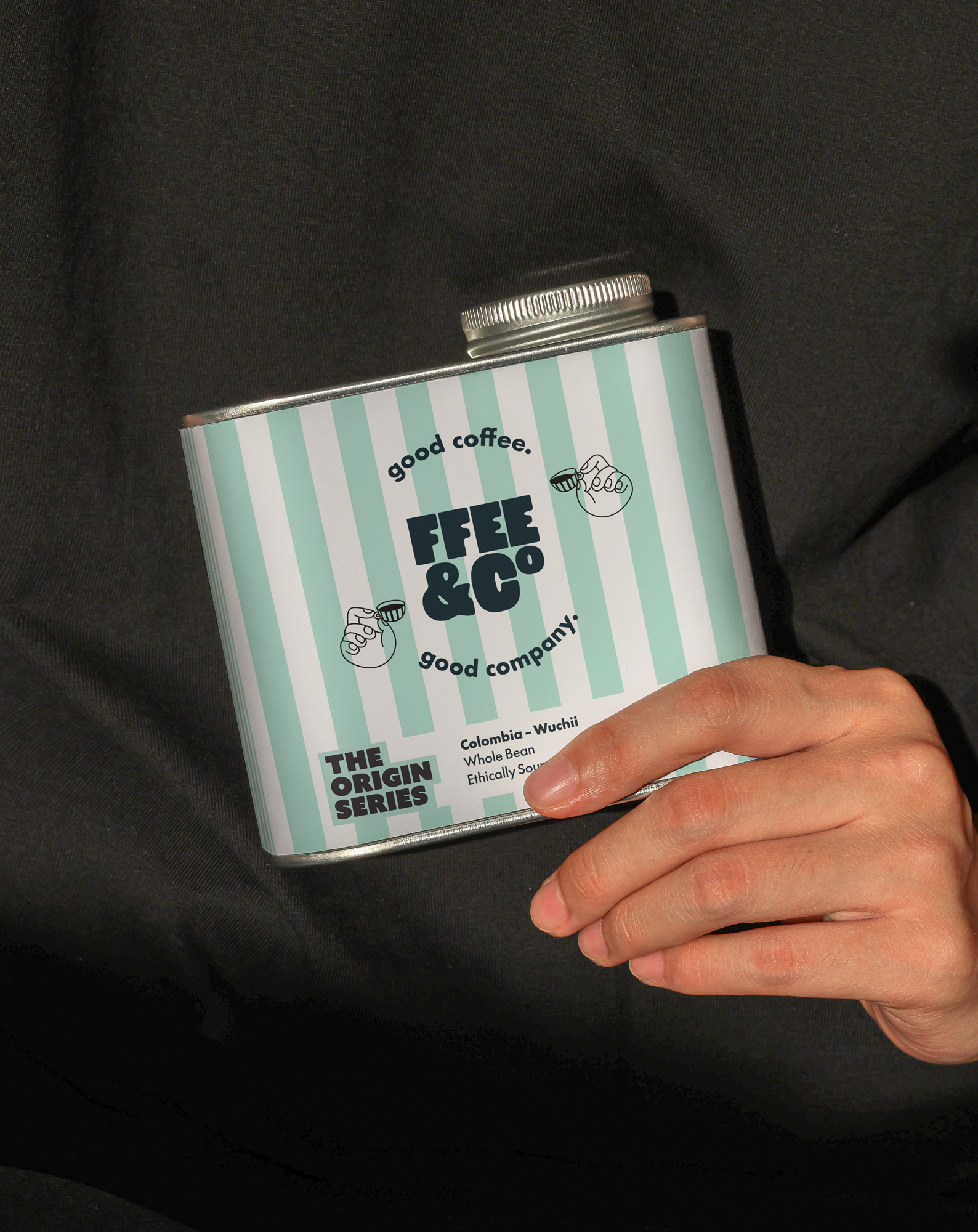 Hand holding a tin of Ffee & Co Origin Series Limited Edition branding against a black background