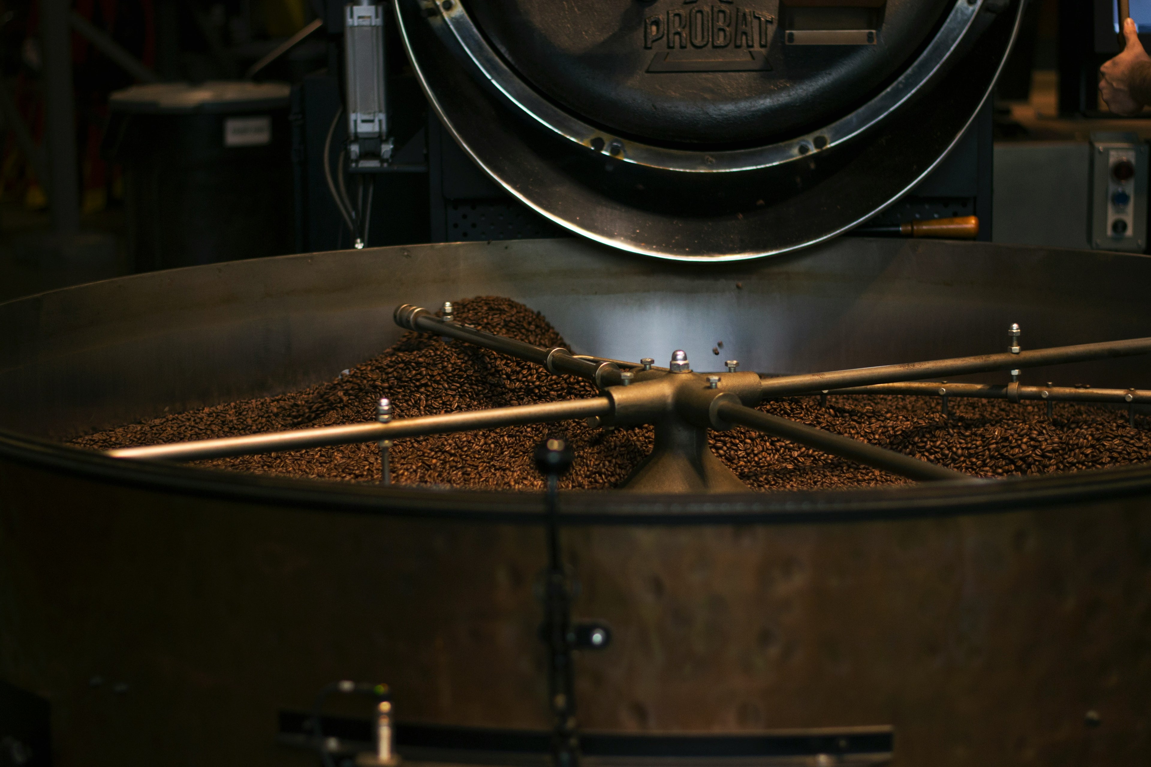 Coffee beans being processed in a large industrial roaster.